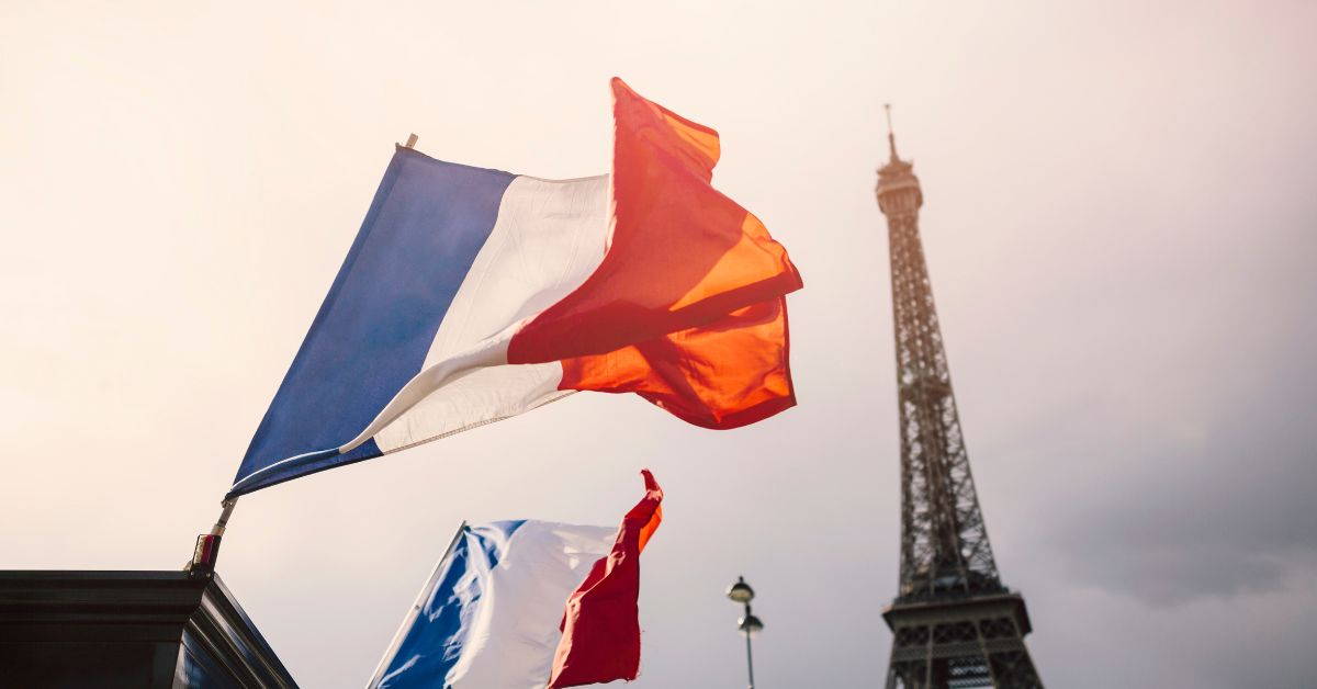 French flags waving in Paris with the Eiffel Tower in the background, representing Forex broker selection and trading in France.