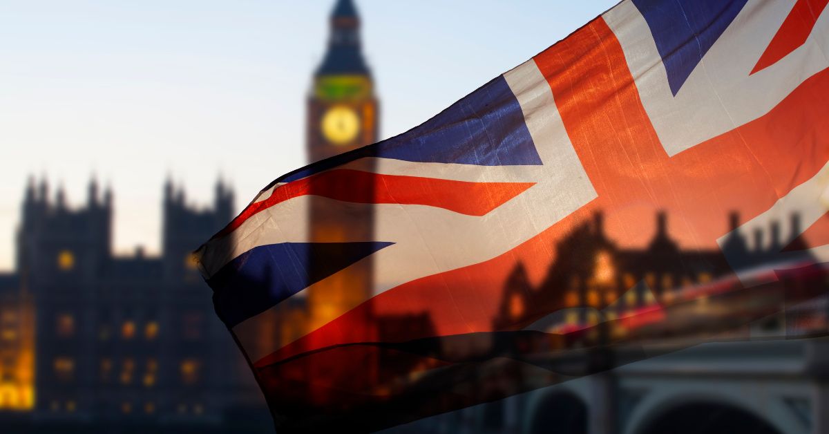 Union Jack flag waving in front of Big Ben and the Houses of Parliament in London, representing Forex brokers and trading in the UK.